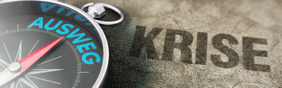 Auf einem Kompass zeigt die Nadel auf Ausweg. Hinter dem Kompass steht das Wort Krise.
