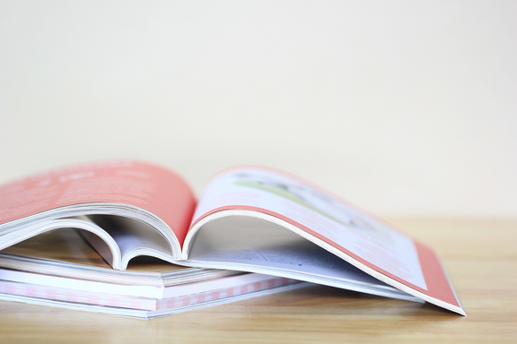 Eine aufgeschlagene Broschüre liegt auf einem Tisch.